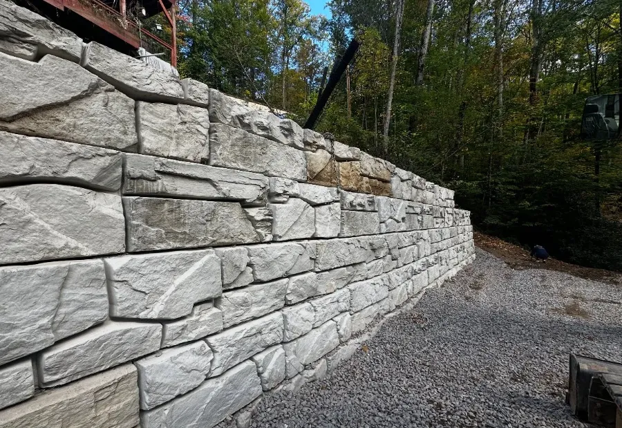 Large block retaining wall along a gravel drive
