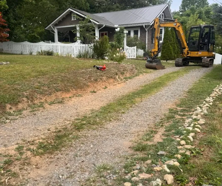 Mini excavator working on a residential gravel drive