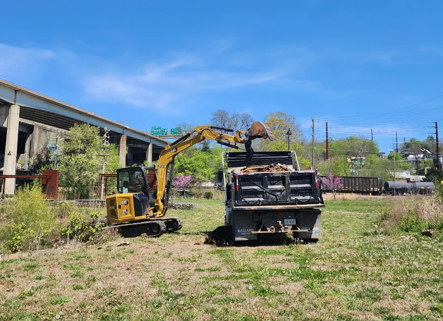 Mini excavator loading a dump truck on a job