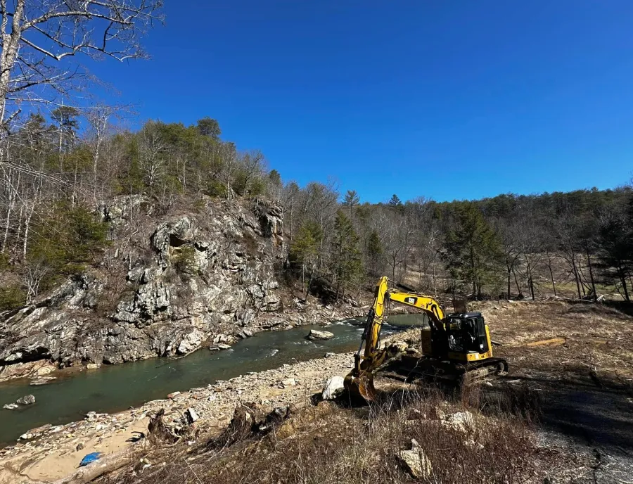 Excavator working along a rocky river bank in Western North Carolina