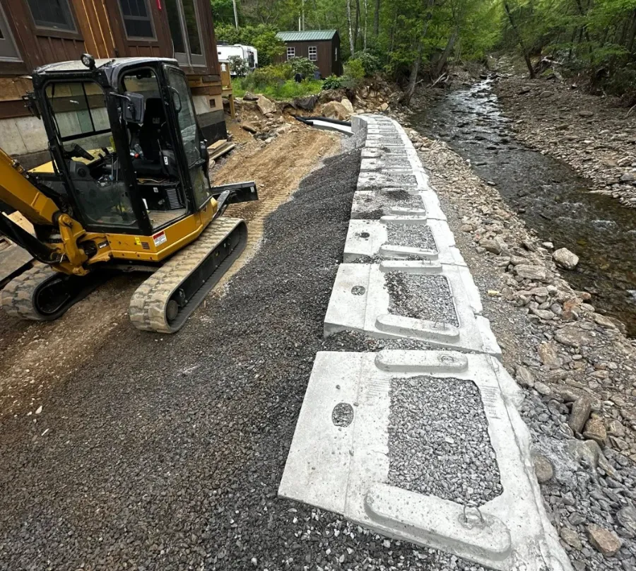Retaining wall blocks being set with an excavator