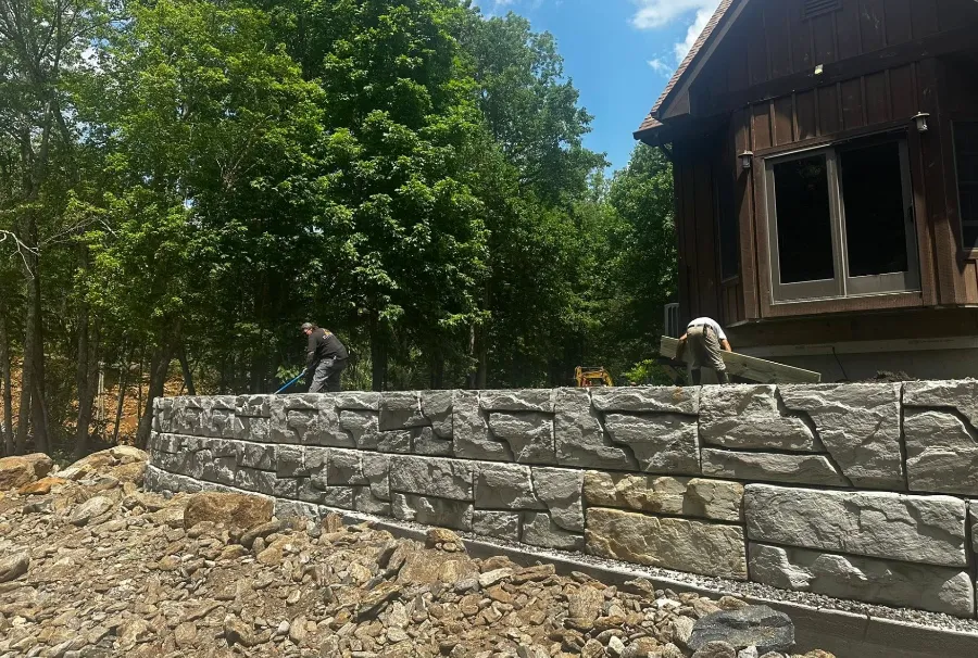 Block retaining wall being built beside a house